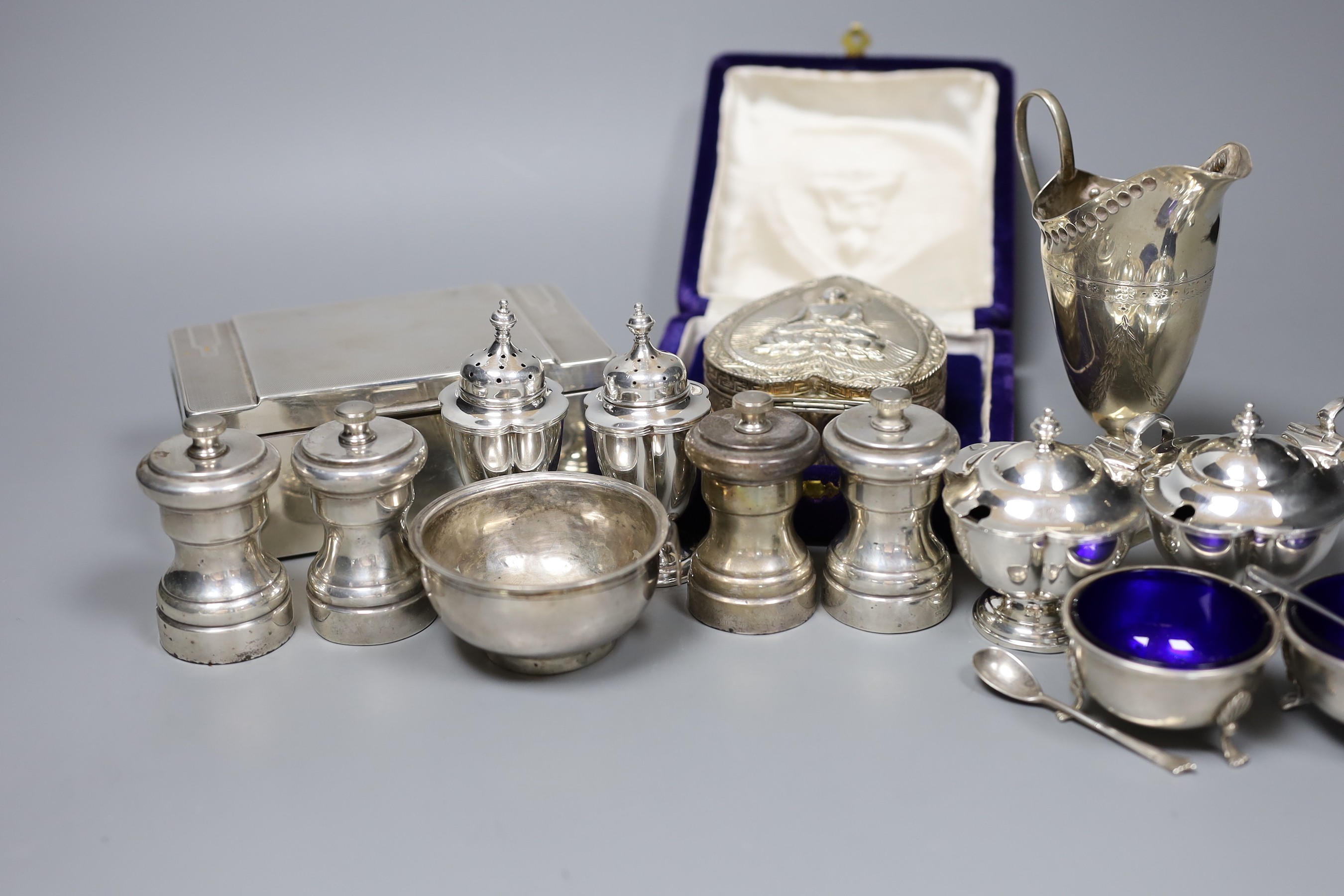 A Victorian engraved silver cream jug, Sheffield 1882, 13cm., engine-turned silver cigarette case, collection of pepper grinders, condiments, etc.